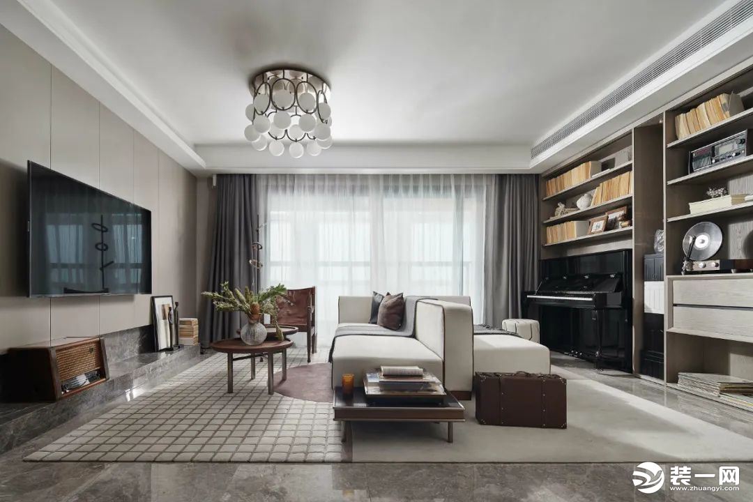 客厅整体现代风格的基调，电视墙采取灰色硬包背景墙的设计，沙发摆在客厅中间位置，布置现代简雅的软装细节