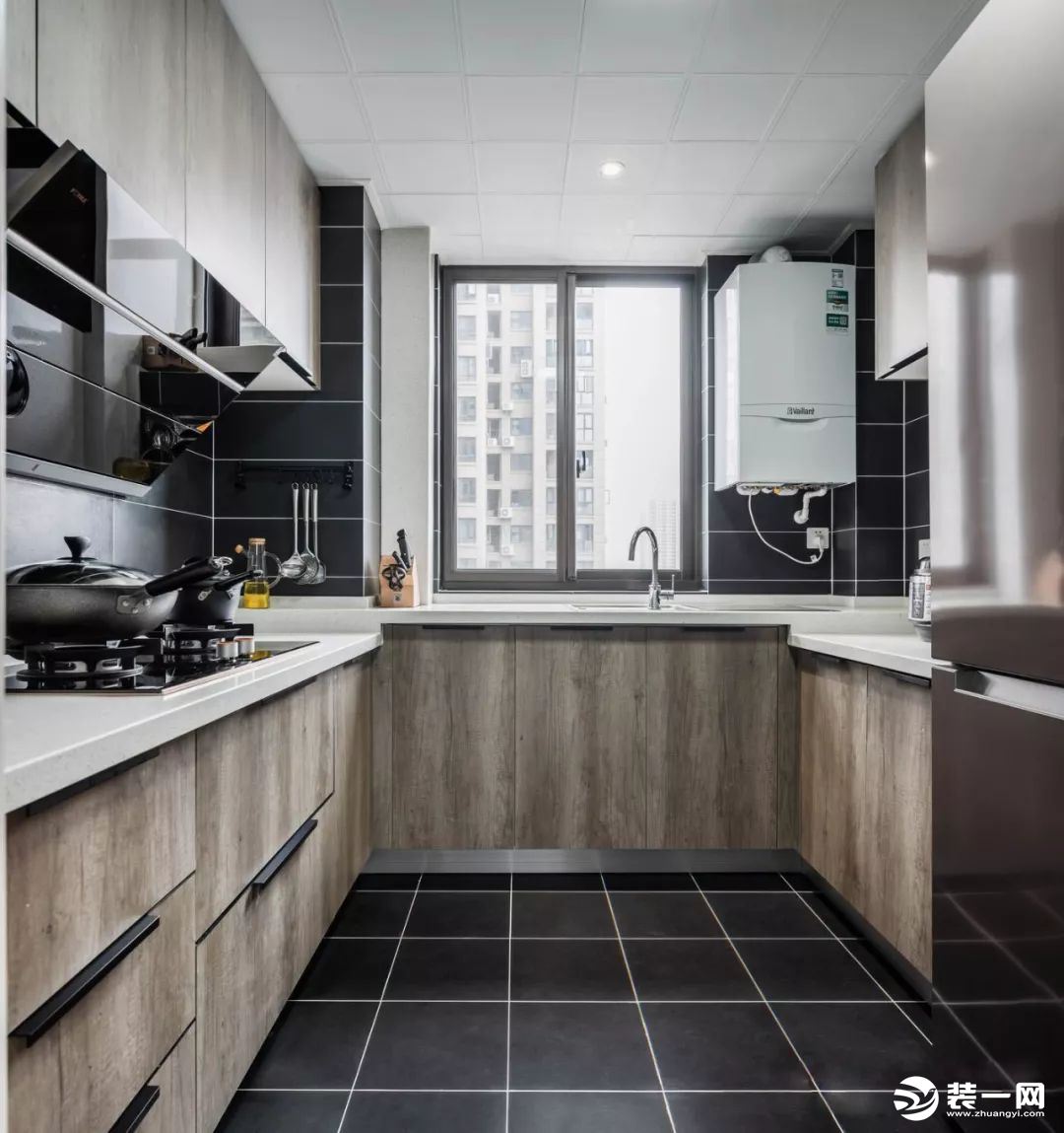 黑色的地板和壁砖让厨房不显脏乱，便于收拾打理。白色的天花板与地面的黑色地砖遥相呼应，白色大理石操作台