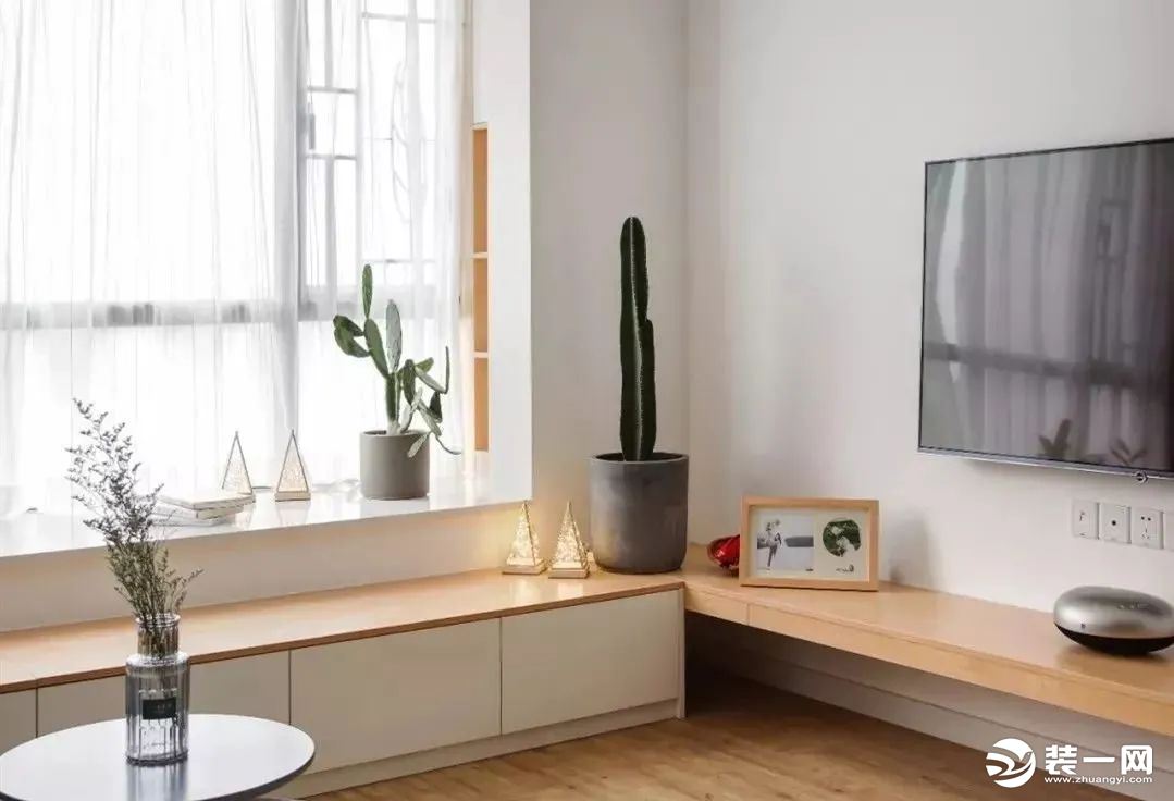 电视柜设计极为简约，长方形原木色搁板直接与飘窗卡座连成一体，原木色加白色的经典搭配，在绿色植物的点缀
