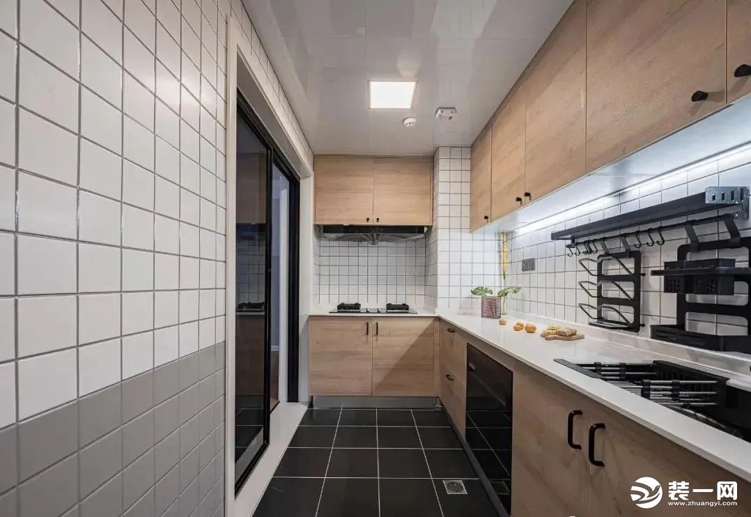 厨房，采用L型的橱柜布局，墙面小方砖延续了分色设计，简洁实用有颜值。