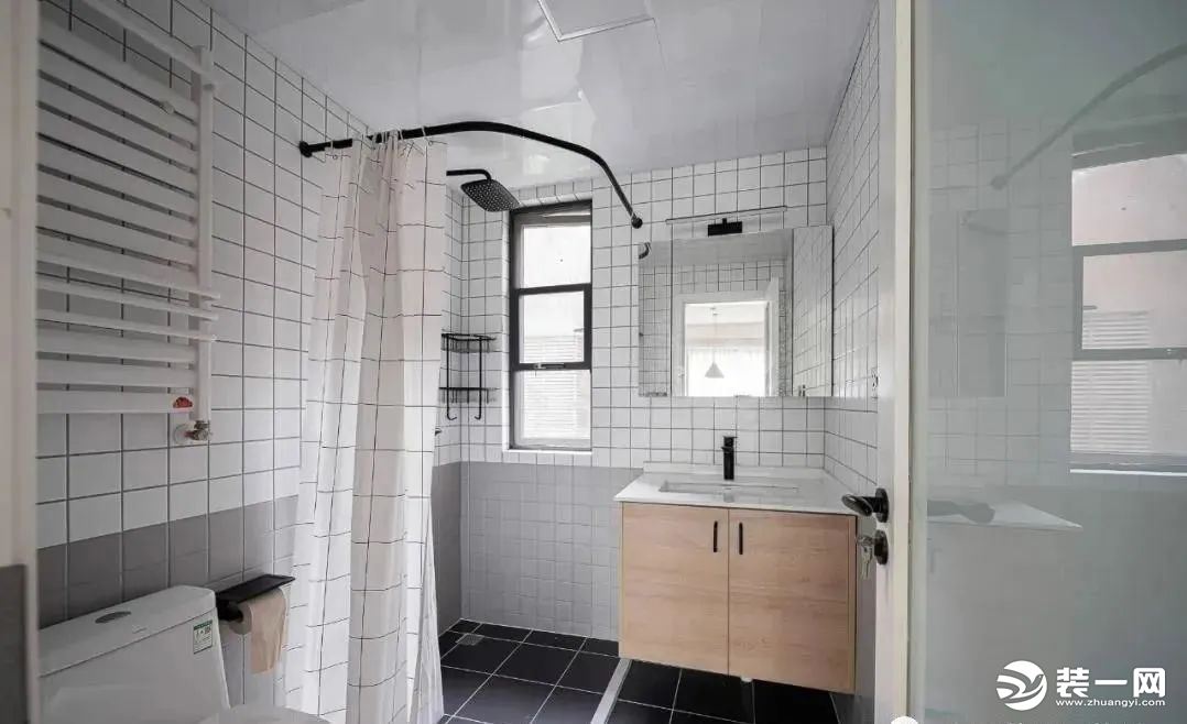 客卫墙面也采用上白下灰的分色处理，用浴帘+防水条做干湿分离，悬空洗手台+镜柜增加了收纳能力。