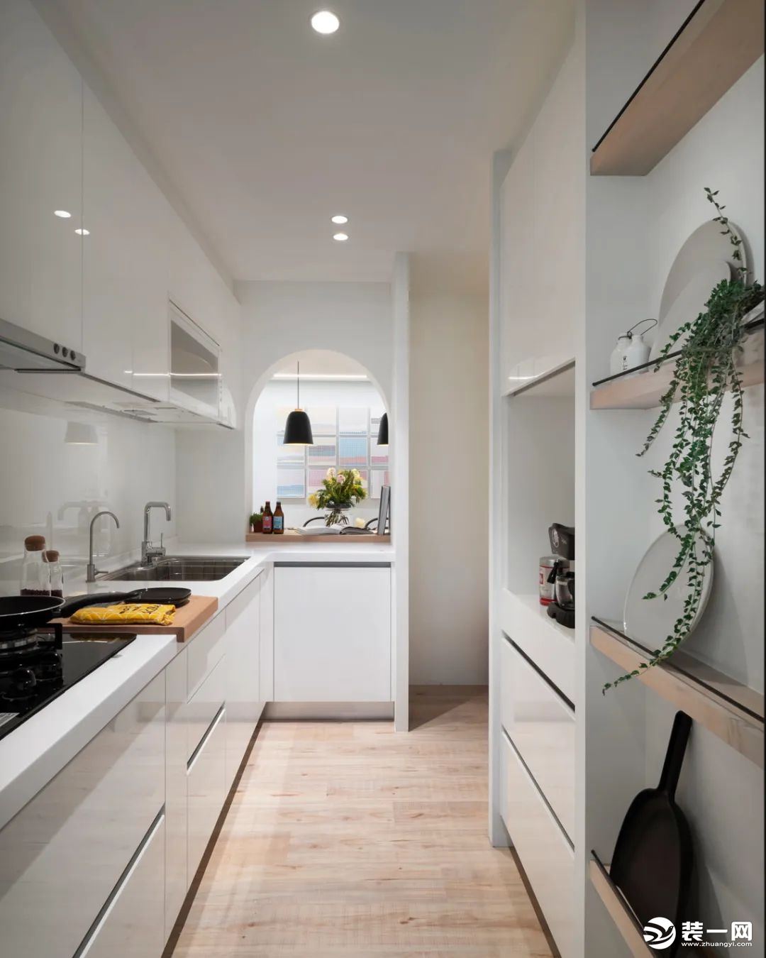 厨房整体白色的橱柜操作台，布置绿植装饰，让做饭氛围显得清新而自然；实用的收纳隔板架，让厨房也有方便的