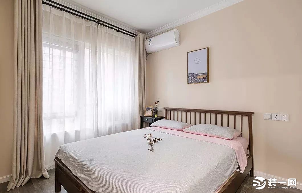 主卧室是选择了更为温馨的米色作为主色调，米色背景墙搭配浅棕色的窗帘和白色的床品，让人感觉非常的舒服。