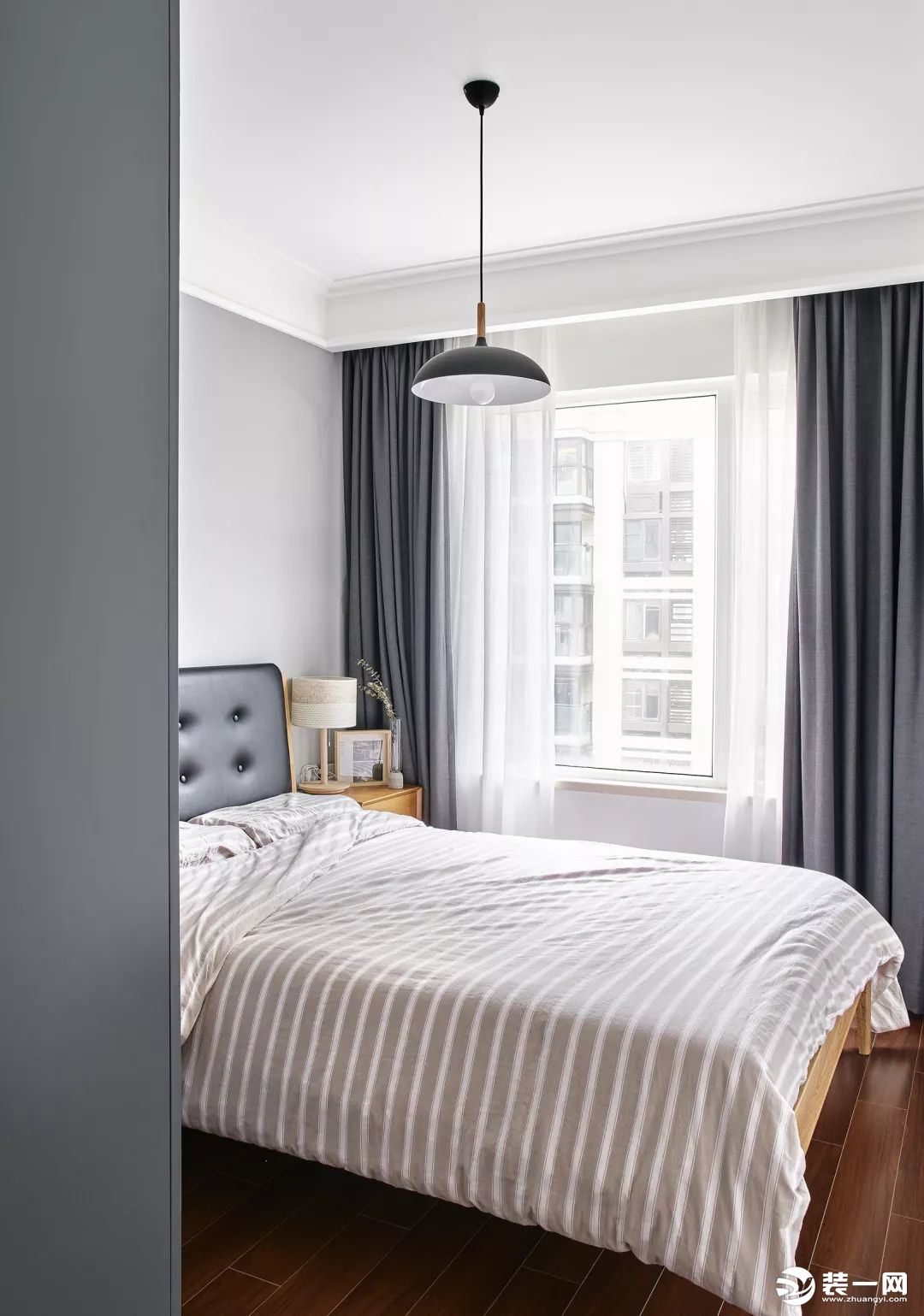  次卧，灰色窗帘与衣柜简洁优雅，搭配黑色的皮艺靠背床及轻松舒适的床品，呈现出一个随性自在的睡眠空间。