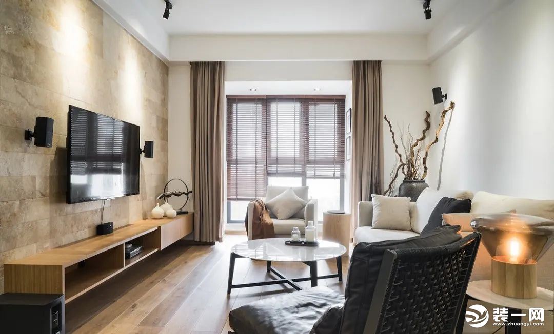 地面通铺木质地板，灰色系窗帘及舒适的米色布艺沙发，铺述场域的自然温润。铁艺椅子搭配黑色皮质坐垫，简约