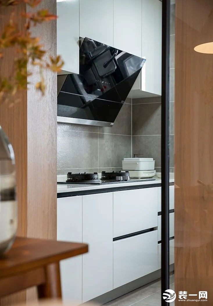厨房，选用了玻璃移门风格，挡油烟不挡光。内部定制了U字型的橱柜布局，提供了充足的收纳+操作空间，充分