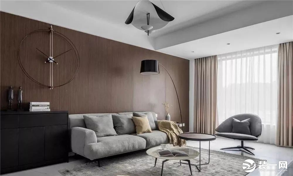 客厅，沙发墙采用木饰板铺贴，搭配金属质感的创意挂表，营造出宁静优雅的家居氛围。