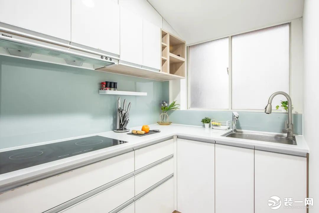 厨房，墙面涂刷清新的淡青色墙漆，搭配白色柜体，一进来就感受到清爽感扑面而来。定制了L型的橱柜，另一侧