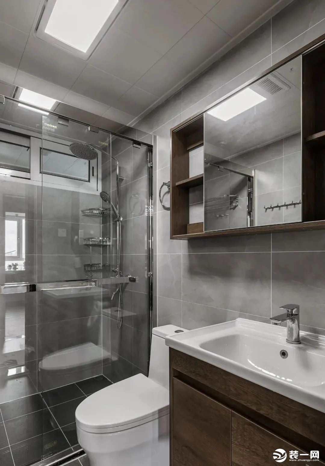 卫生间用浅灰色的墙砖搭配木色的浴室柜，灰+木是经典搭配。镜柜的使用，满足了一家三口日常卫生间的储物需