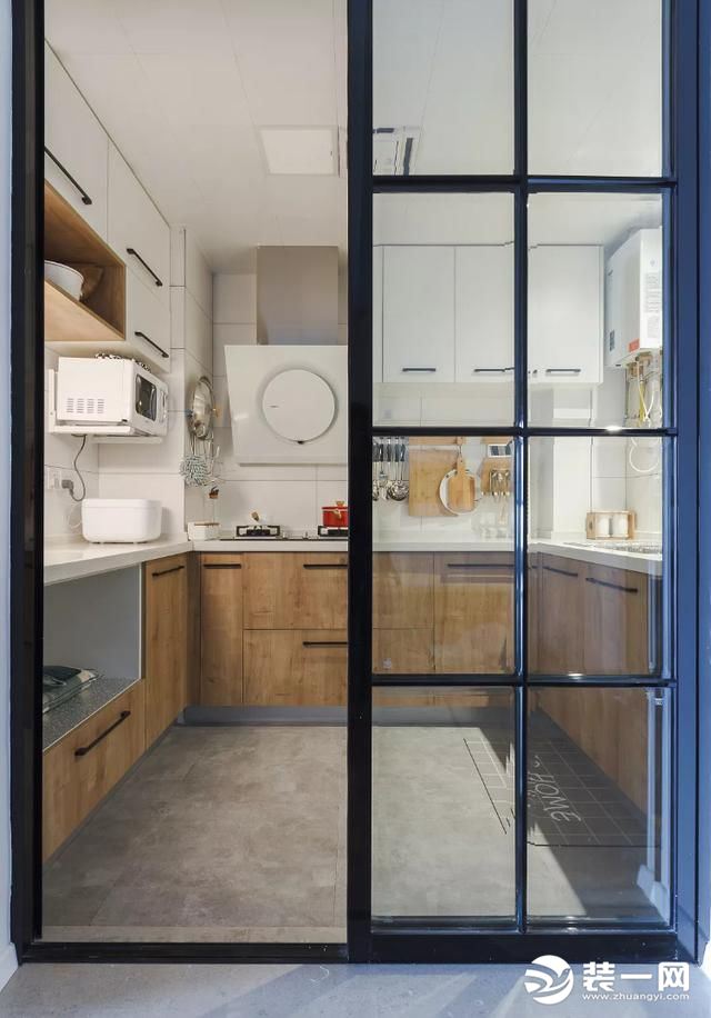  厨房隔门使用黑框玻璃推拉门，一定程度上可保持采光与通透性，推拉门也比正常开合的门要节省空间，适合中
