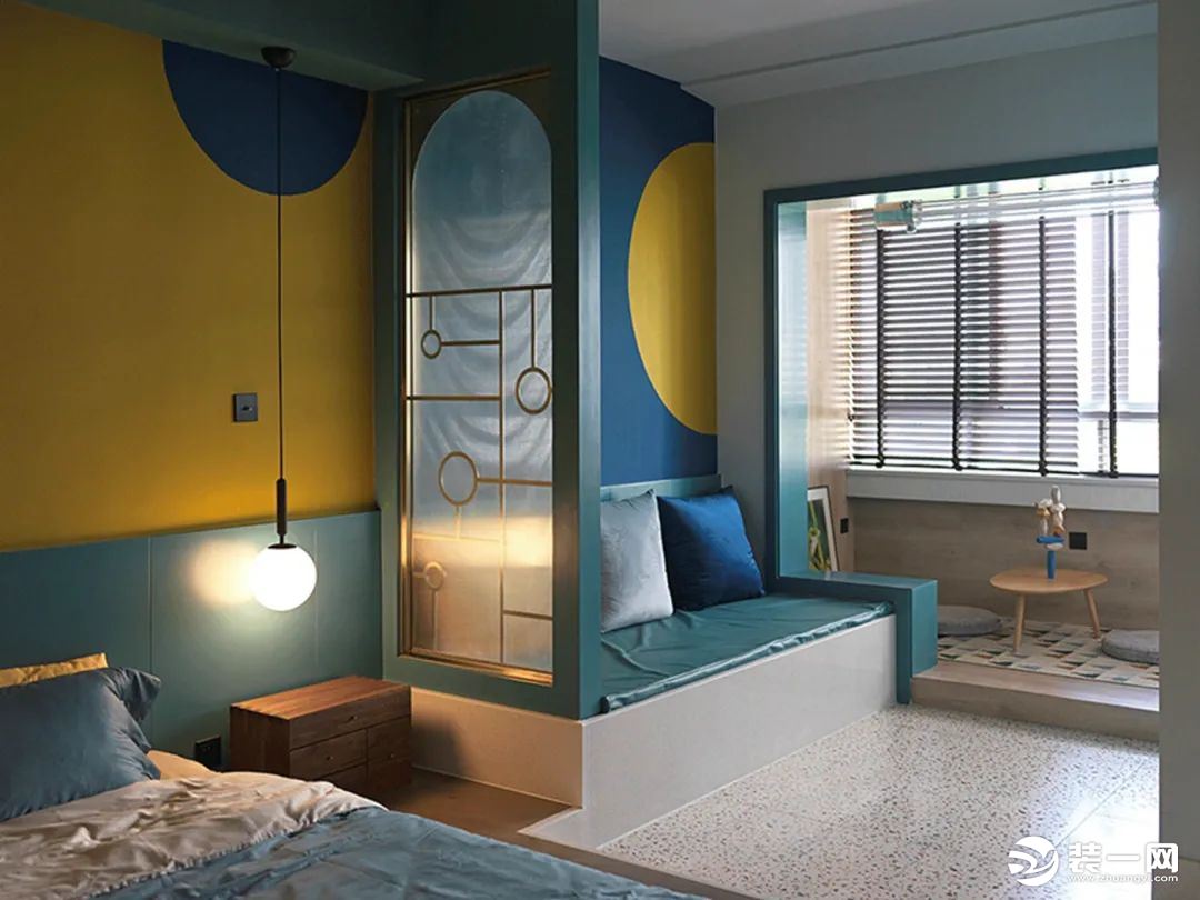小公寓的客厅与卧室之间，只有一道玻璃+金属结合的屏风，墙面也是以黄色+蓝色的深色设计，搭配丹绿装饰