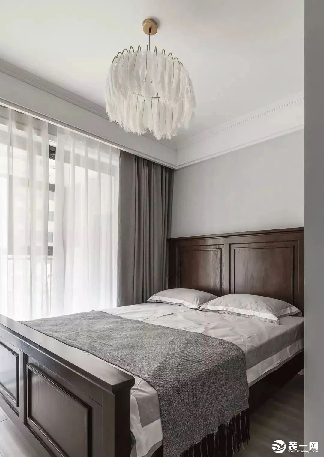 卧室浅灰色空间布置深棕色实木高背床，点缀一盏白色羽毛吊灯。   主 卧 