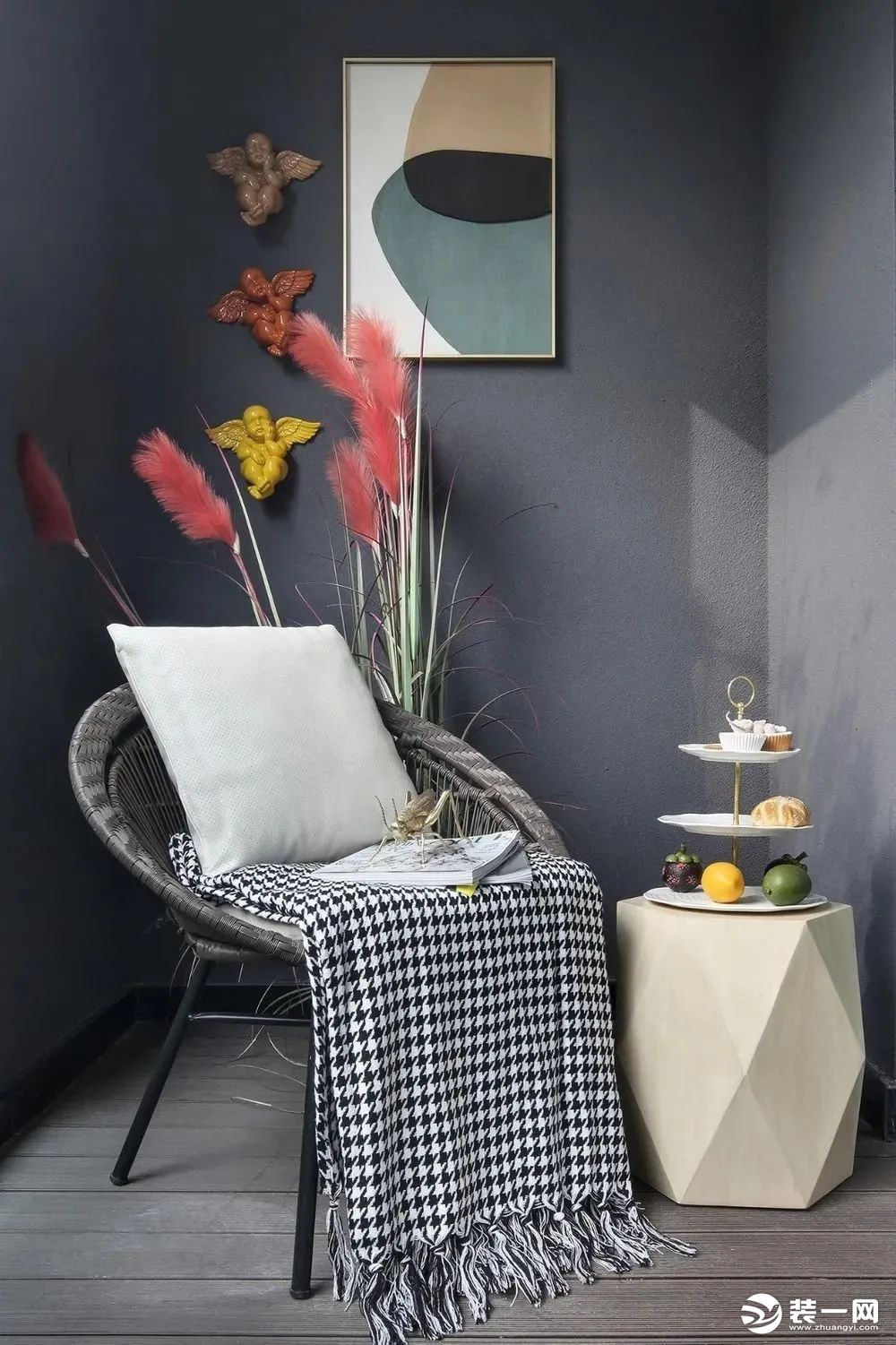 阳台在灰色木地板的基础，灰色的墙面上挂一幅装饰画，布置上休闲桌椅，在鲜花与果盘的装饰点缀下，也是显得