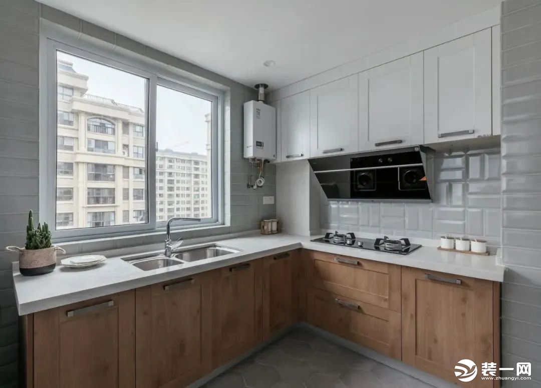 厨房在灰色六边砖的地面基础，墙面是白色的面包砖，结合木色橱柜与白色吊柜，L形的操作台空间，让做饭的氛