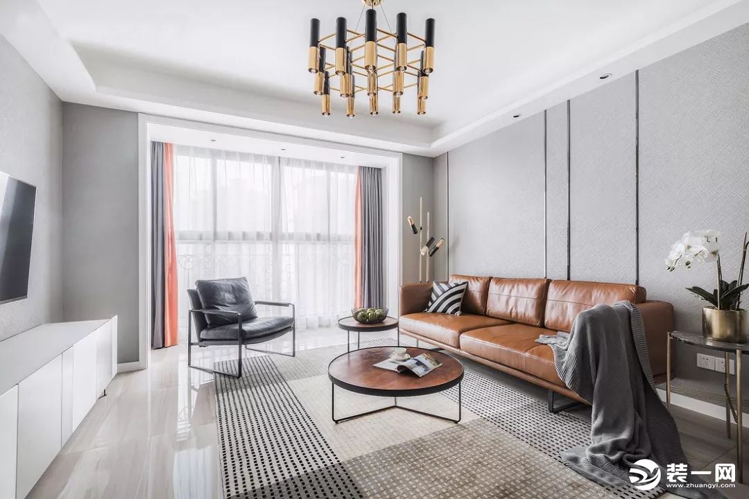 客厅在时尚的浅灰色调下搭配了深棕色的皮质沙发，散发出一种高档的品质感，也让空间配色丰富不少。