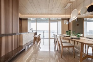 餐厨区也以木质感的硬装与家具搭配，开放式的餐厨设计结合大面积的落地窗，带来一种明亮宽敞的空间氛围感。