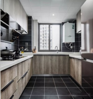 黑色的地板和壁砖让厨房不显脏乱，便于收拾打理。白色的天花板与地面的黑色地砖遥相呼应，白色大理石操作台
