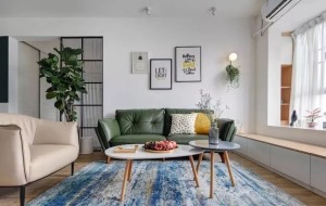 客厅的整体搭配非常微妙，绿色真皮沙发与米色真皮沙发撞色搭配，轻奢又文艺，蓝色的抽象艺术风的地毯缓和了
