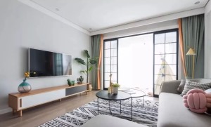 电视背景墙没有过多修饰，纯色块墙面搭配木色电视柜，撞色窗帘与局部的亮色软装呼应。