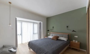 主卧，床头背景墙涂刷牛油果绿的墙漆，搭配原木家具，加上无主灯设计，更有助于睡眠。