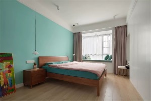 主卧室的床头背景墙被刷成了绿色，搭配粉色的床品和窗帘，给人一种清新、浪漫的感觉。床尾的衣柜当中留出了