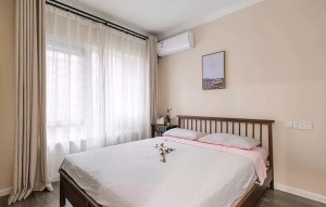 主卧室是选择了更为温馨的米色作为主色调，米色背景墙搭配浅棕色的窗帘和白色的床品，让人感觉非常的舒服。