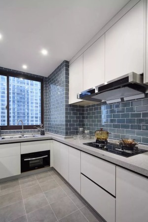 厨房，水泥灰地砖搭配工字铺蓝灰调墙砖，白色隐形拉手的橱柜，干净整洁。