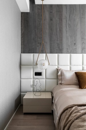 主卧，床头背景墙采用浅色软包+深色木地板上墙的组合，尽显高级质感。床尾墙面打造了衣柜+化妆台+电视柜