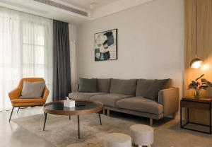 客厅，大白墙+仿水泥地砖，搭配灰色系的布艺沙发、地毯，以及圆形简约木质茶几，天然质朴。