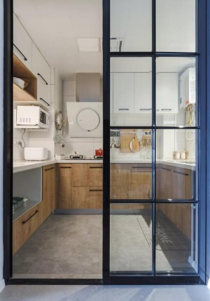  廚房隔門使用黑框玻璃推拉門，一定程度上可保持采光與通透性，推拉門也比正常開合的門要節省空間，適合中
