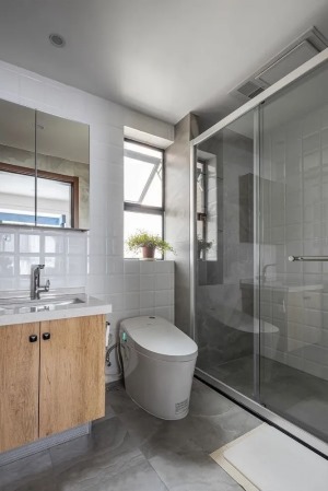 主卫以灰白两色为主调，木质浴室柜为简约的空间注入一份温暖，淋浴区增加了壁龛空间，让洗浴用品有了容身之