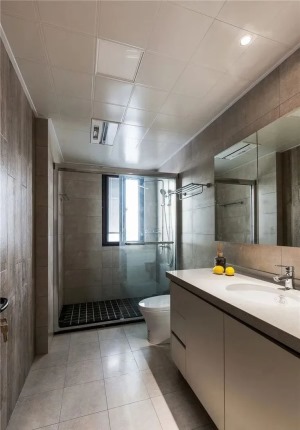  卫生间以灰色为主调，通过淋浴间的玻璃隔断进行干湿分离，整体干净利落整洁有序。