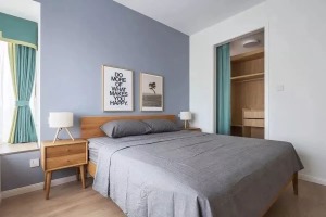 主卧室的床头背景墙是刷成了灰蓝色，和床品颜色相近又有些差别，这样的搭配让层次更加分明。卧室的衣柜被改