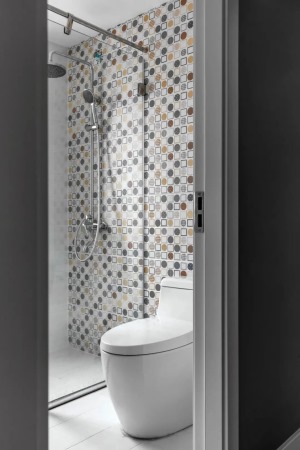 主卫的淋浴花洒安装墙面贴着马赛克墙砖，与床头墙的墙布视觉相互呼应，带来一种文艺的简约感。