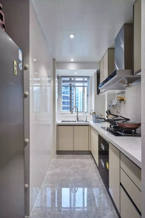 厨房内部是做了L形的橱柜布局方案，白色的墙砖和灰色的地砖搭配乳白色的橱柜，让厨房看起来更有层次感又不