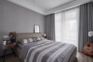 次卧的设计非常简单，灰色调的背景墙和灰色调的软装结合，不同层次的灰色让卧室不会那么单调，简约年轻的感