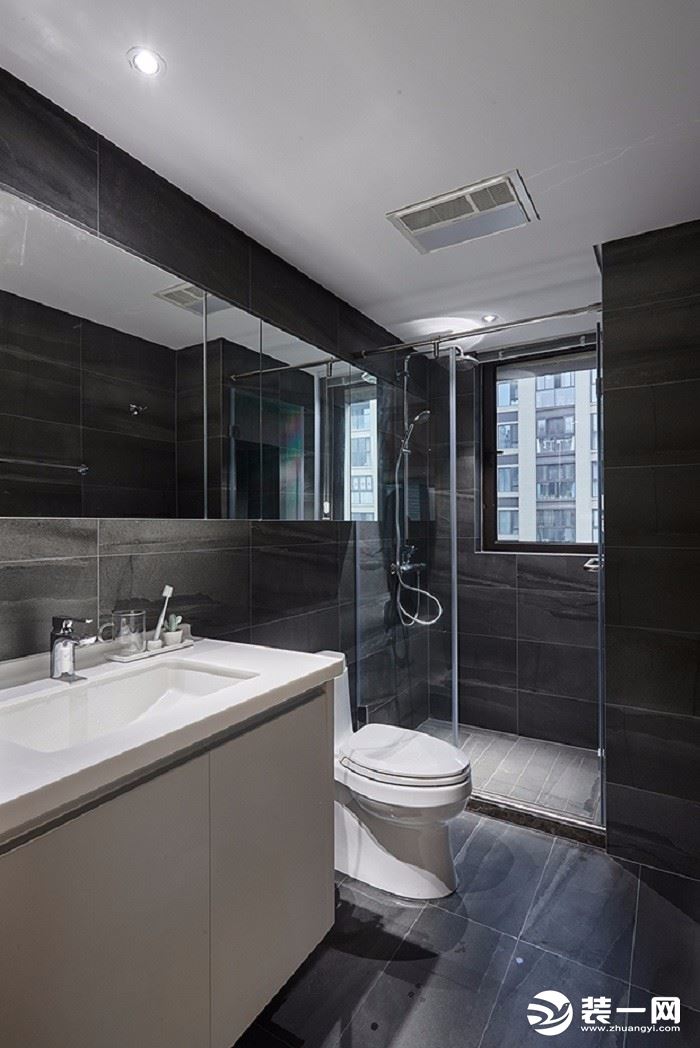 卫生间选用中性色，以灰黑色的地砖配搭白色的柜门与洁具