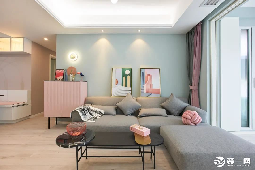 客厅草绿色墙面富有生机与活力，L型沙发舒适又实用，浅灰色降低了客厅整体的色彩饱和度。