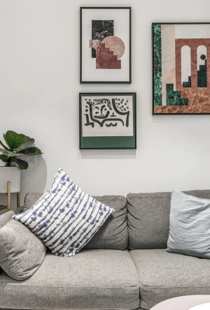 客厅，选用小型布艺沙发，装饰画和绿植增加空间活力。
