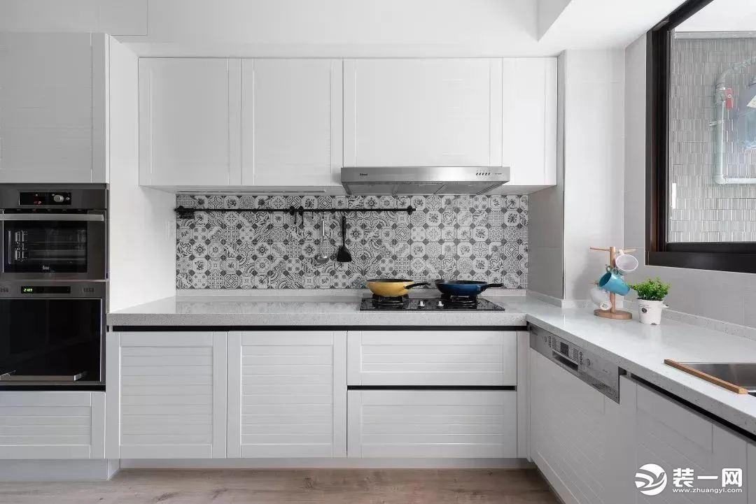 厨房呈L型，黑白主色调让整个空间看起来更加整洁明亮，线条感十足。