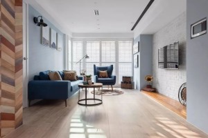 客厅选用了英国皇家蓝作为墙面主色，高贵大方，搭配木地板和白色百叶窗，让人放松，也是一家人三口休闲、