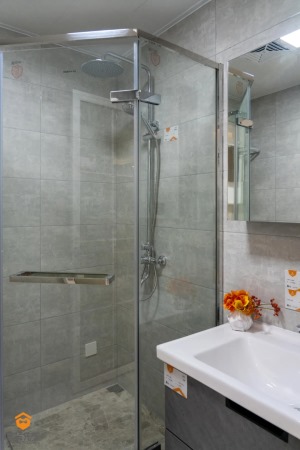 洗手间以玻璃门隔断划分，做成干湿分离，灰色花纹的瓷砖增加了美感和便利性。