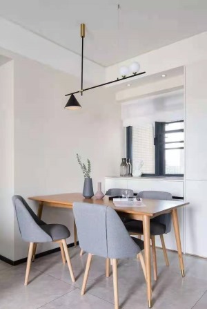 原木极简风的餐桌，长板凳+温莎椅的组合，餐桌上方吊着三盏白色吊灯，使得用餐氛围温馨舒适。