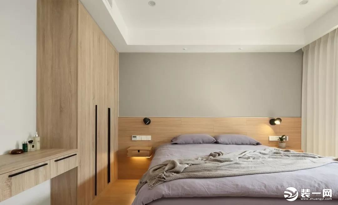 主卧床头背景运用了半高护墙与墙纸相结合，灯光的装饰让整体空间更丰满。
