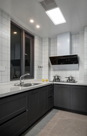 厨房在灰色地面砖的基础，墙面则是小白砖，而深灰色的橱柜设计，搭配在这个现代大方的厨房空间里，也是显得