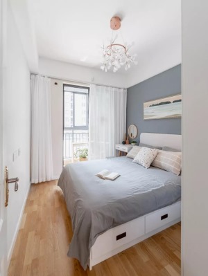次卧床头墙是蓝灰色的，搭配灰色床单，床底是抽屉式收纳，小小的卧室也是实用而又简洁大气。