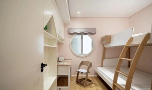 儿童房，整体选择粉白色主调，搭配地板与高低床的木质元素，在充足的照明等下显得明亮而温馨，书桌部分藏于