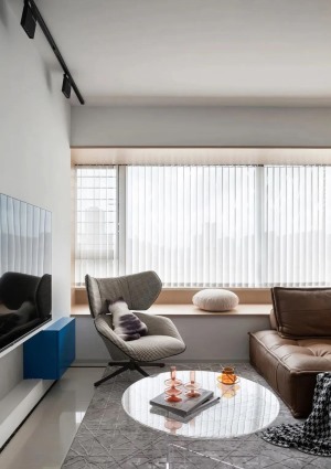 灰色的柔软地毯将客厅家具聚拢起来，中和简约带来的清冷感，增添几分温馨与家的温度，将客厅的飘窗充分利用