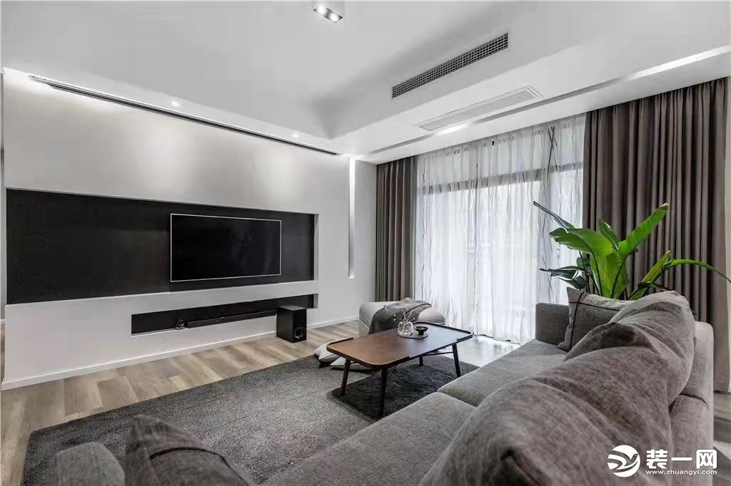 客厅整体现代简约，洁净大方的基础摆上简约灰色的地毯沙发，让空间充满舒适自然的气息感