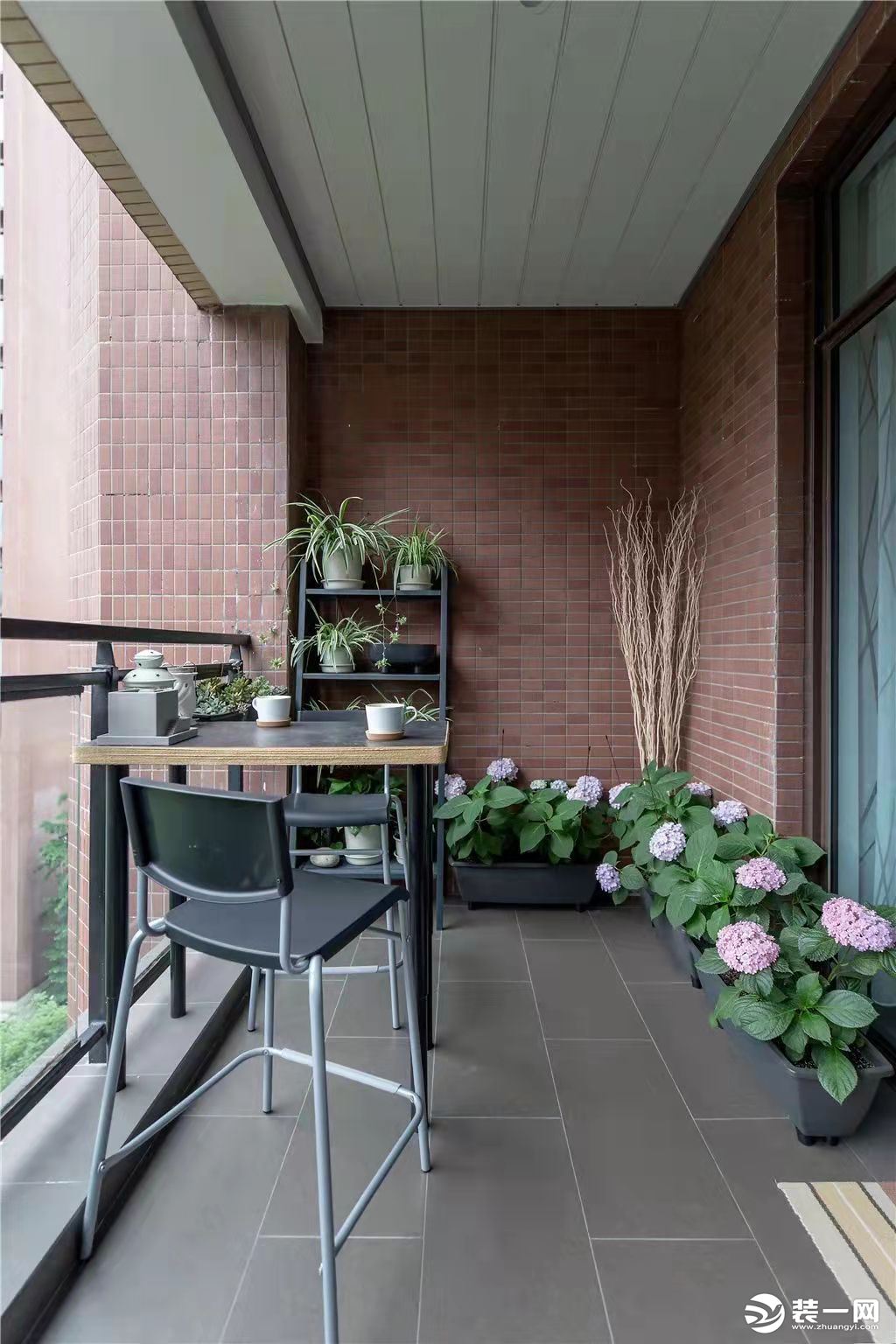 阳台以休闲功能为主，中间放上一张茶台，侧边布置了绿植架与外面的树枝相映，呈现出一个自然轻松的休闲空间